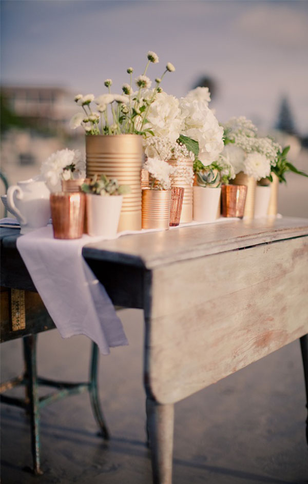Usa latas de diferentes tamaños y píntalas con pintura metálica para transformarlas en elegantes floreros